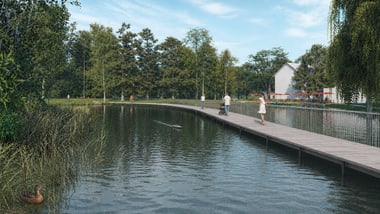 Mehrere Personen gehen auf einem Steg über einen Teich mit Enten im Wasser.