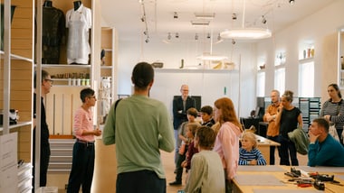 Gruppe von Menschen in einem Raum mit Tischen und Ausstellungen.