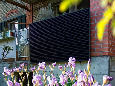 Schwarzer Solarpanel an einem Balkon.