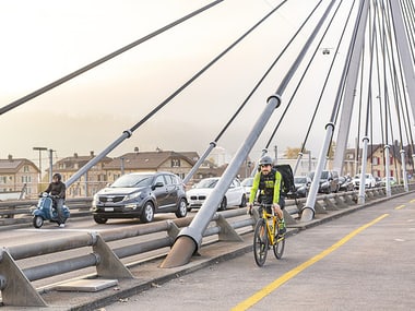 Brücke mit Autos und einem Kurier auf einem Fahrrad.