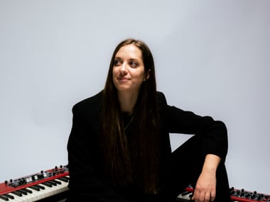 Gery sitzt auf dem Boden zwischen zwei Keyboards.