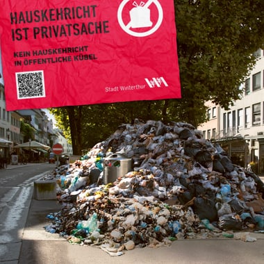 Grosser Müllhaufen auf einer Strasse mit einem Warnschild oben.
