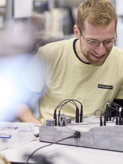 Mann und Kind sitzen am Tisch und experimentieren mit Elektronik.