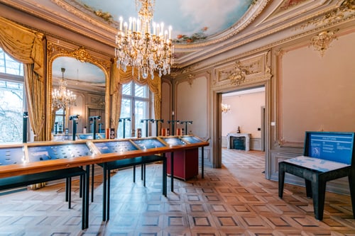 Eleganter Raum mit Kronleuchtern und Ausstellungsstücken.
