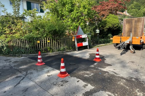 Strassenszene mit Verkehrshütchen und Anhänger.