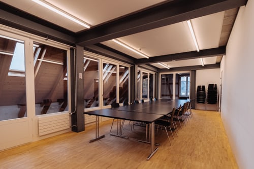 Leerer Konferenzraum mit langen Tisch und Stühlen.