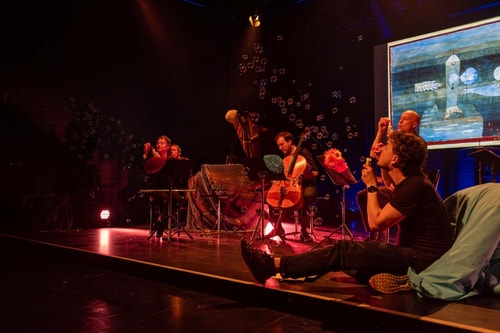 Bühnenperformance mit Musikern und Seifenblasen.