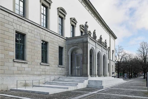 Historisches Gebäude mit Skulpturen und grossem Eingang.