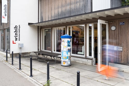 Ausssenansicht der Bibliothek Wülflingen. Eingang mit Glasfenstern.