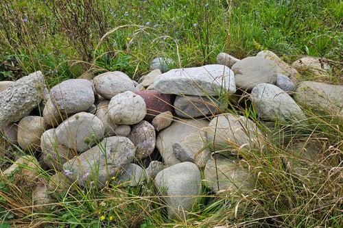 Steinhaufen im grasbewachsenen Feld.