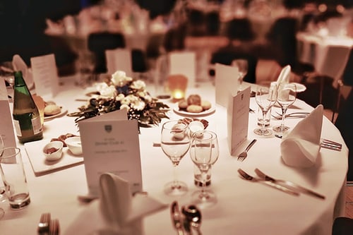 Eleganter gedeckter Tisch mit Blumen und Menükarten.