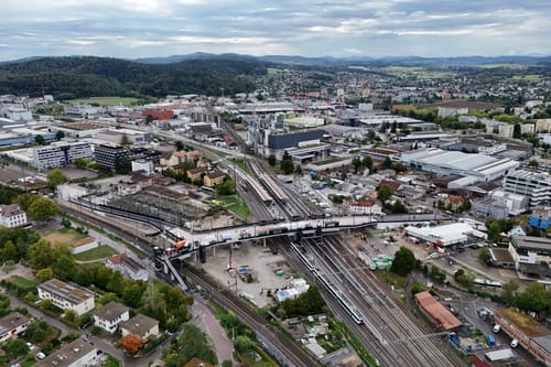 Luftaufnahme einer Stadt mit Gleisen und Gebäuden.