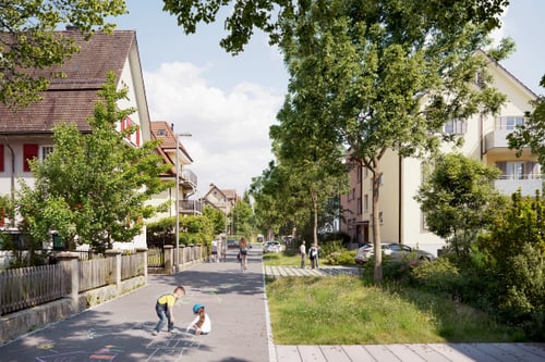 Kinder malen auf einer Strasse mit Häusern und Bäumen.