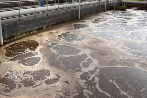 Wasserbecken mit Schaum an einer Kläranlage.