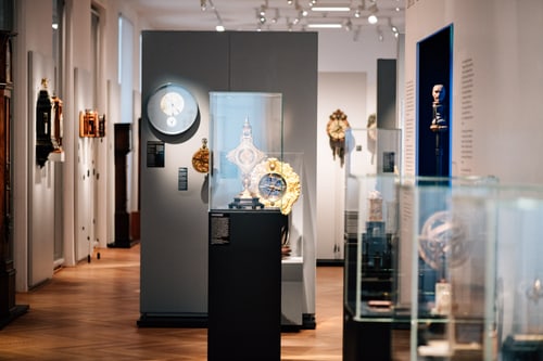 Innenansicht eines Museums mit alten Uhren und Ausstellungsstücken.