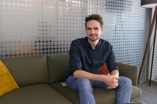 Person sitzt auf einem Sofa in modernem Büro.
