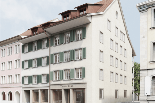 Mehrstöckiges Gebäude mit grünen Fensterläden.