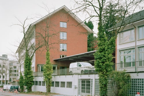 Rotes Backsteingebäude mit Lieferwagen auf dem Balkon geparkt.
