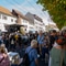 Menschenmenge auf einem Strassenfest mit Bühne und Ständen.