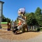 Bild des Spielplatzes "Observatorium" im Stadtgarten beim Schulhaus Altstadt: Spielplatz mit Klettergerüst und Rutsche neben einem Gebäude.
