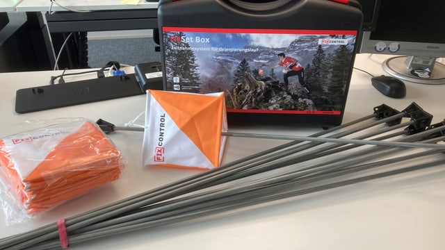 Ausrüstung für Orientierungslauf auf einem Schreibtisch.