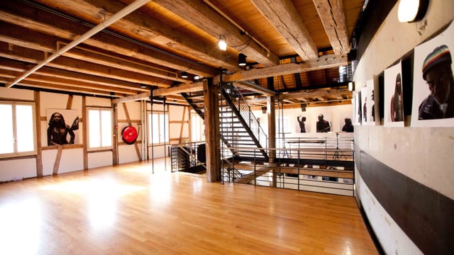 Geräumiger Holzraum mit Treppe und Kunstwerken an den Wänden.