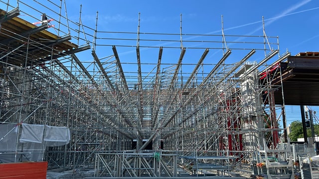 Metallgerüste auf einer Baustelle vor blauem Himmel.