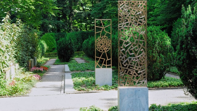 Garten mit geometrischen Metallskulpturen und Wegen.