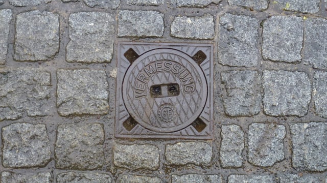 Pflastersteine mit Metallabdeckung in der Mitte.