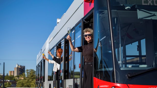 Einweihung der Querung Grüze: Carmen Walker-Späh, Martina Blum und Christa Meier prosten den Gästen aus einem Bus zu.