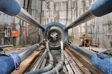Grosser Tunnel mit Rohren und Kabeln innen.