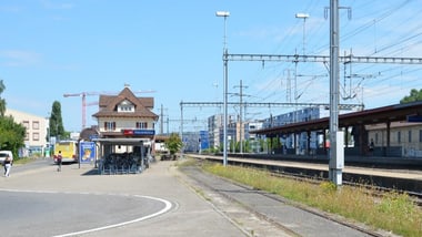 Bahnhof mit Gleisen, Bahnsteigen und Gebäuden.