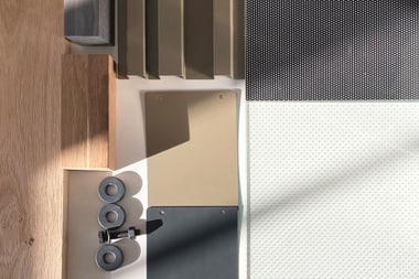 Muster aus Stoff-, Holz- und Metallproben in neutralen Farben.