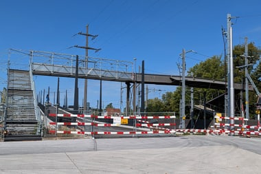 Fussgängerbrücke über Bahngleise mit Absperrungen.