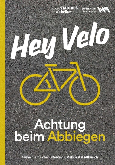 Plakat mit gelbem Fahrrad und Text 'Hey Velo, Achtung beim Abbiegen'.