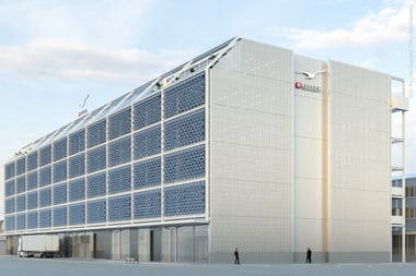Grosses modernes Gebäude mit Glasfassade unter blauem Himmel.