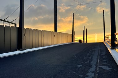 Brücke im Sonnenuntergang mit Metallgeländern.